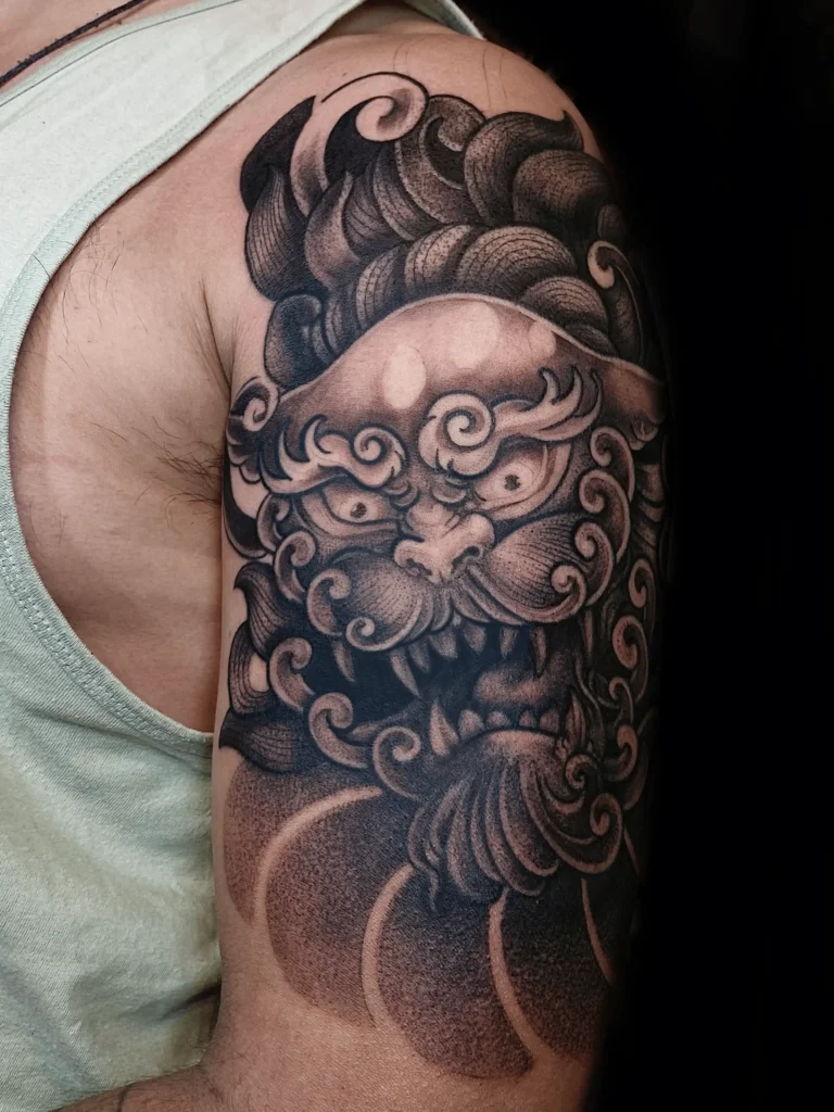 León guardián oriental tatuado en brazo